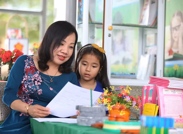 Bà Trần Thị Hương, Phó giám đốc sở GD&ĐT tỉnh Quảng Bình xem một bài viết chữ đẹp của học sinh trường Tiểu học Quảng Liên (Quảng Trạch - Quảng Bình)