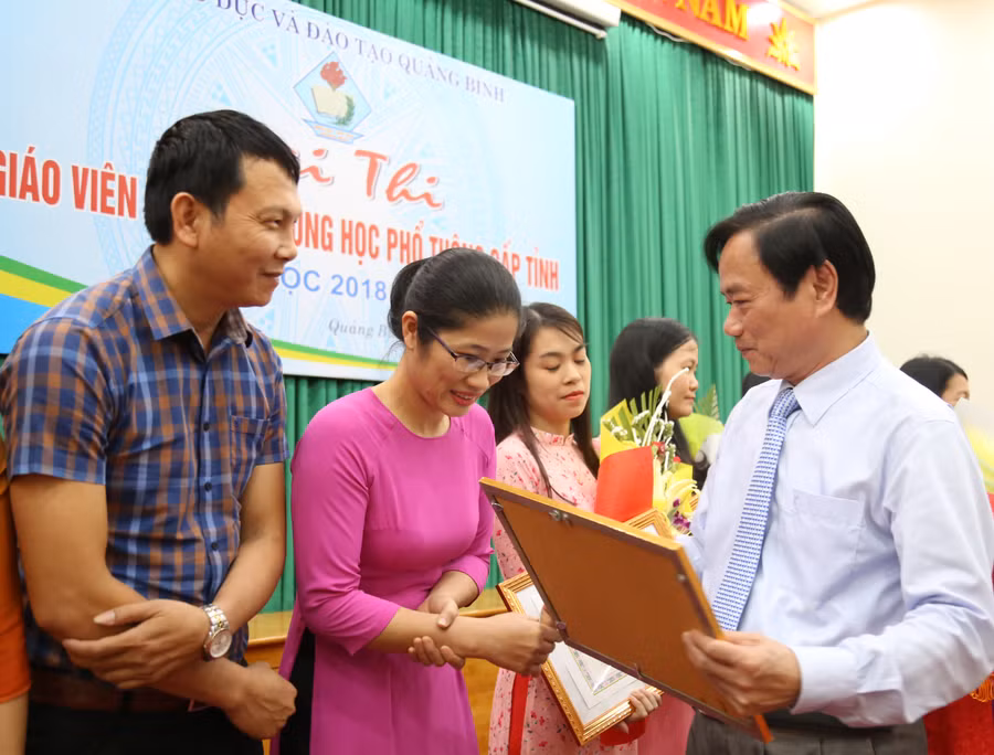 Ông Đinh Quý Nhân, giám đốc Sở GD&ĐT tỉnh Quảng Bình tặng giấy khen cho giáo viên đạt giải nhất của cuộc thi.