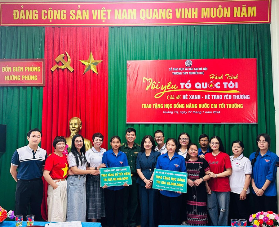 Bà Nguyễn Thanh Nga, Trưởng phòng GD&ĐT huyện Hướng Hóa cùng thầy giáo Phạm Quang Huy, Trường THPT Nguyễn Huệ trao tặng sổ tiết kiệm các thầy, cô giáo và các em học sinh có hoàn cảnh đặc biệt khó khăn.