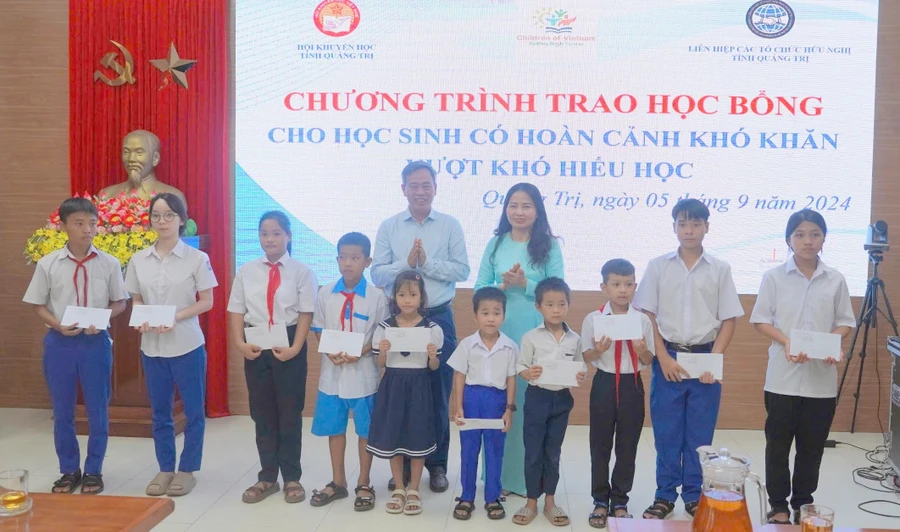 Phó Bí thư Thường trực Tỉnh ủy Nguyễn Đăng Quang và bà Dương Thị Hải Yến, Chủ tịch Hội Khuyến học tỉnh trao học bổng động viên học sinh.