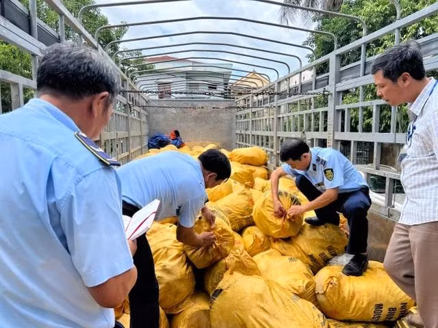 Lực lượng chức năng kiểm tra, thu giữ hàng hóa trên xe. (Ảnh: Nguyễn Chiến)