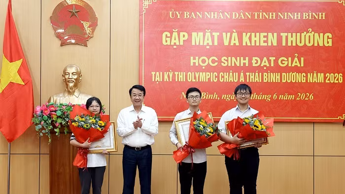 Chủ tịch UBND tỉnh Ninh Bình trao bằng khen và tặng hoa chúc mừng các em học sinh.