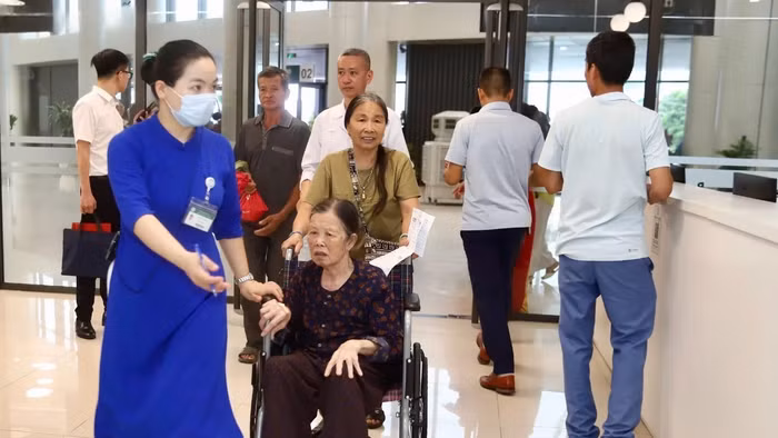 Nhân viên y tế hỗ trợ người dân đến khám, chữa bệnh tại Bệnh viện Bạch Mai cơ sở Ninh Bình trong ngày đầu bệnh viện đi vào hoạt động.