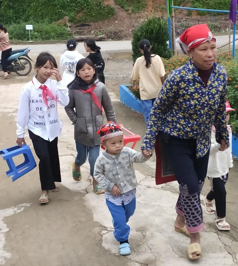 Bà Vàng Tả Mẩy, thôn Bản Kim, xã Thanh Kim dẫn theo 2 con theo dự Lễ khai giảng.