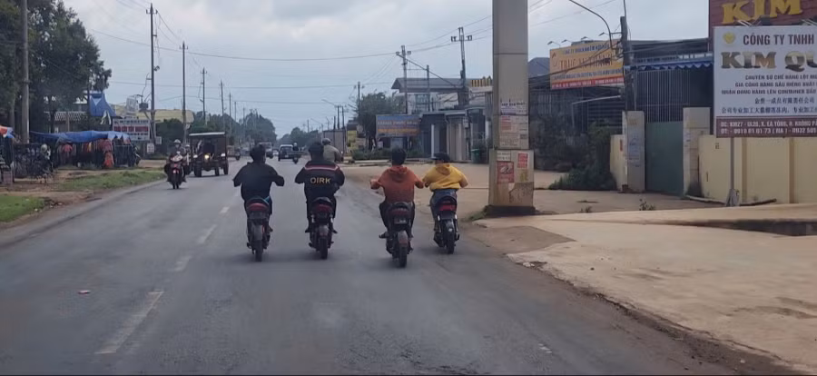 Học sinh đi xe đạp điện dàn hàng 4 trên quốc lộ 26 đoạn qua huyện Krông Pắc. (Ảnh cắt từ clip)