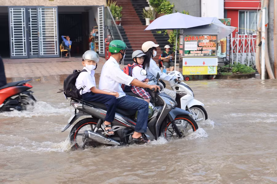 Phụ huynh ở Cần Thơ đưa con đến trường trong mùa triều cường. Ảnh: T.P
