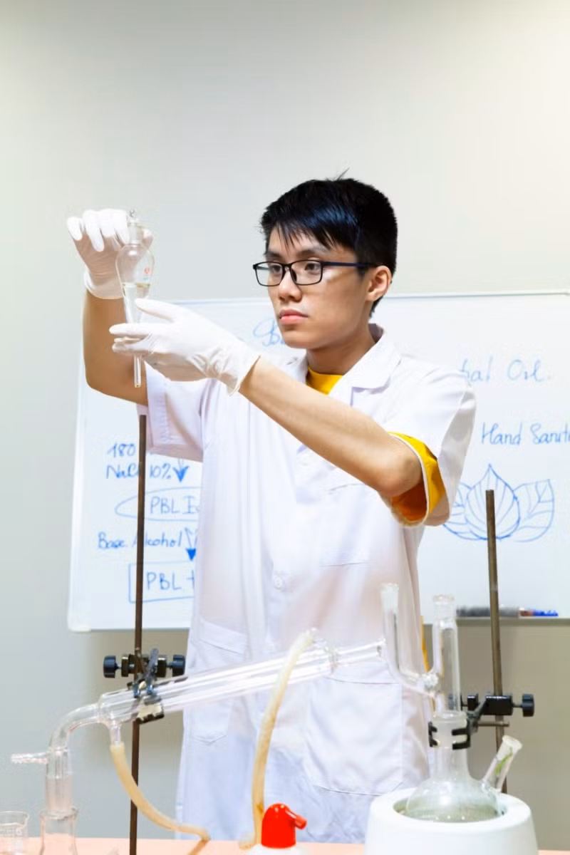 Cát Huy Dương đang thực nghiệm quan sát sự tách lớp giữa tinh dầu và nước.