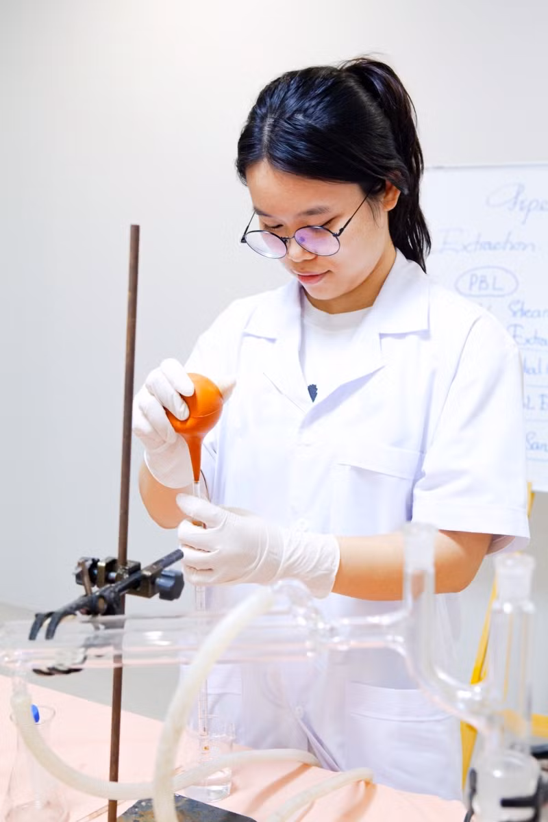 Vũ Khánh Linh đang thực nghiệm đếm giọt để tính định lượng dầu trong hỗn hợp thu được sau chưng cất.