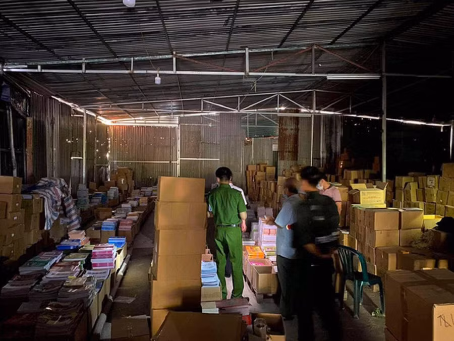 Lực lượng làm nhiệm vụ phá án kiểm tra một kho lưu trữ sách giáo khoa giả liên quan đến vụ án. Ảnh: TP.