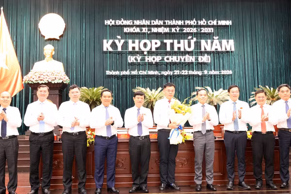 Tân Phó Chủ tịch UBND TPHCM Trương Minh Huy Vũ nhận hoa chúc mừng từ lãnh đạo TPHCM. Ảnh: Cổng TTĐT TPHCM.