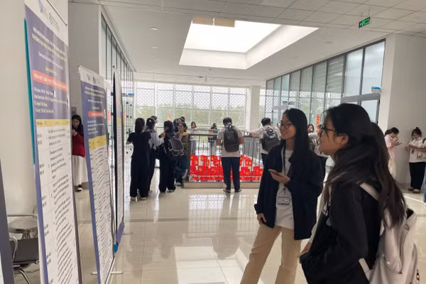 Bạn trẻ theo dõi tóm tắt các nghiên cứu qua poster được giới thiệu tại hội nghị. Ảnh: Hà An.