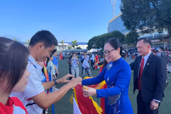 Thứ trưởng Bộ GD&ĐT Nguyễn Thị Quyên Thanh trao cờ lưu niệm cho các đoàn vận động viên. Ảnh: Hà An.