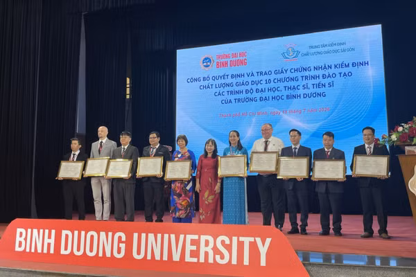 Cán bộ, giảng viên Trường Đại học Bình Dương đại diện cho 10 ngành đào tạo nhận chứng nhận kiểm định. Ảnh: Hà An.