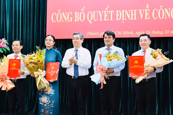 Từ phải sang, ông Lê Trương Hải Hiếu, ông Bùi Thanh Nhân, bà Hồ Thị Ánh Tuyết, ông Lê Văn Phong nhận quyết định của Thành ủy TPHCM. Ảnh: Việt Dũng/SGGP.
