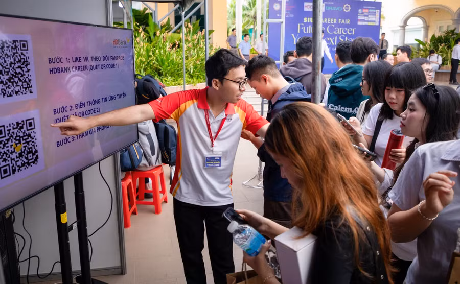 Học sinh, sinh viên tìm hiểu thông tin việc làm tại gian hàng một doanh nghiệp về tài chính, ngân hàng trong chương trình hướng nghiệp tại Trường Đại học Quốc tế Sài Gòn. Ảnh: SIU