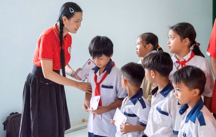 Cô Nguyễn Thị Minh Tâm trao học bổng Nhất Tâm cho học sinh có hoàn cảnh khó khăn. Ảnh: M.H