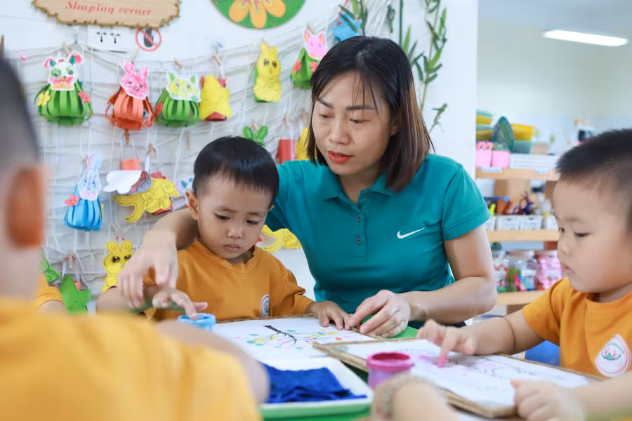 Cô Bùi Thị Thu Hà - giáo viên Trường Mầm non An Khánh B (Hoài Đức, Hà Nội) hướng dẫn trẻ sử dụng màu vẽ tranh. Ảnh: TG