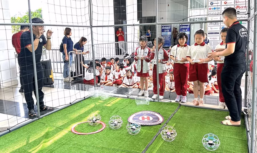 Học sinh thích thú khi trải nghiệm trò chơi đá bóng trên không (drone soccer). Ảnh: SHTP-IC