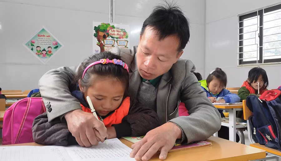 Thầy Sung Văn Vư cầm tay nắn nót từng nét chữ cho học trò.
