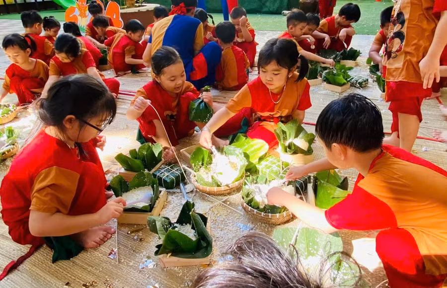 Trẻ Trường Mầm non Hoa Đào (Quận 12, TPHCM) gói bánh chưng dịp Tết Nguyên đán 2024. Ảnh: NTCC