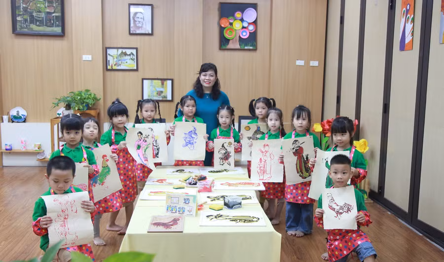 Cô Nguyễn Thị Mỹ Ngọc - giáo viên Trường Mầm non Quang Trung cùng trẻ tạo hình những bức tranh Hàng Trống. Ảnh: Vân Anh