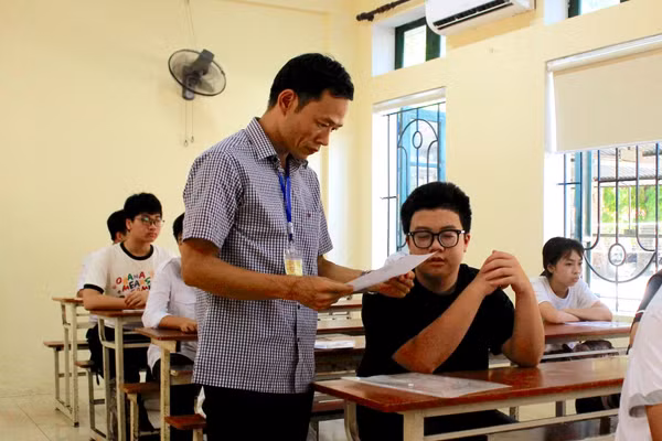 Cán bộ coi thi tại Hội đồng thi Trường THPT Lê Quý Đôn hướng dẫn kiểm tra lại thông tin thí sinh.