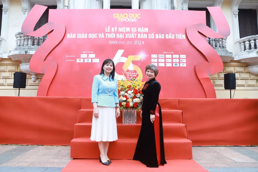 Phó Giám đốc Sở GD&ĐT Nam Định Nguyễn Thị Minh Nguyệt (trái) tặng hoa chúc mừng lãnh đạo BBT Báo Giáo dục và Thời đại nhân dịp lễ kỷ niệm 65 năm xuất bản số báo đầu tiên. Ảnh: Đình Tuệ.