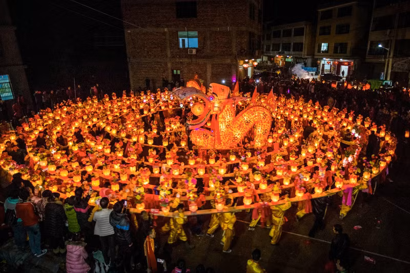 Trong lễ hội ở quận Shangrao, tỉnh Giang Tây, Trung Quốc dân làng mang đèn lồng Rồng băng qua các ngôi làng và ngõ hẻm để chào đón Lễ hội đèn lồng. (Ảnh: Huang Ying) Hình ảnh những chú rồng rực rỡ qua ống kính nhiếp ảnh gia