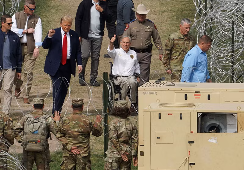 Ông Donald Trump và Thống đốc Texas Greg Abbott ra hiệu với các thành viên của Lực lượng Vệ binh Quốc gia khi ông Trump đến thăm biên giới Mỹ-Mexico tại Eagle Pass ngày 29/2. Chùm ảnh Tổng thống Biden và ông Trump thăm biên giới phía Nam Hoa Kỳ
