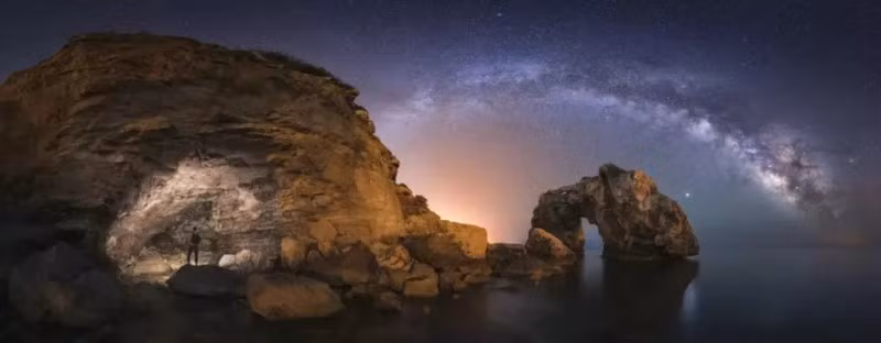 Tác phẩm "Los arcos y la cueva" của Marc Marco. Bức ảnh toàn cảnh ban đêm trong đó có được vòm Dải Ngân hà đi qua phía sau vòm đá có tên là Es Pontàs. Cuộc thi Nhiếp ảnh Thiên nhiên công bố người chiến thắng