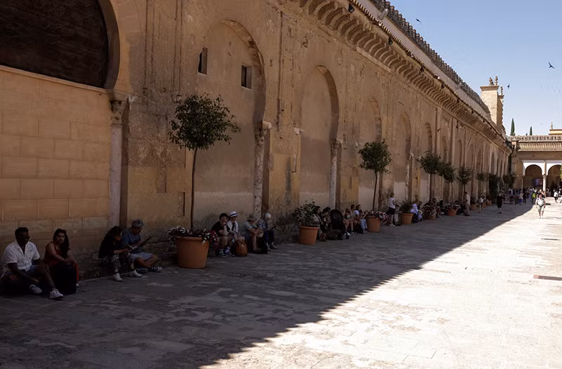 Khách du lịch nghỉ dưới bóng râm bên ngoài một nhà thờ Hồi giáo ở Cordoba, miền nam Tây Ban Nha, ngày 21/6. Ảnh: REUTERS/Jon Nazca Hình ảnh nắng nóng cực độ thiêu đốt ở khắp 4 châu lục
