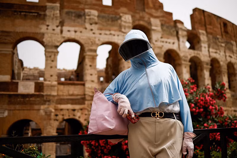 Bà Olie đến từ Trung Quốc đứng gần Đấu trường La Mã giữa đợt nắng nóng ở Rome, Italy, ngày 20/6. Ảnh: REUTERS/Guglielmo Mangiapane Hình ảnh nắng nóng cực độ thiêu đốt ở khắp 4 châu lục