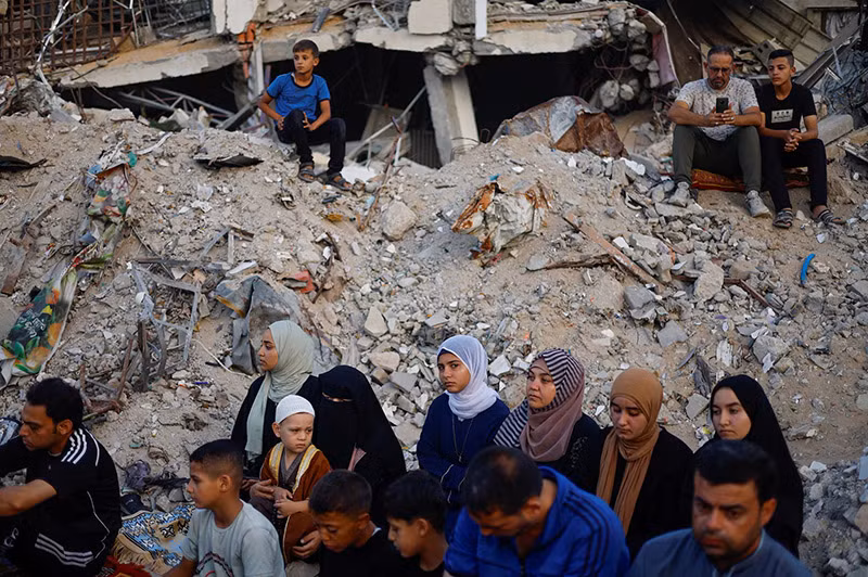 Người Palestine tổ chức cầu nguyện Eid al-Adha bên đống đổ nát của nhà thờ Hồi giáo al-Al Rahma bị phá hủy bởi các cuộc không kích của Israel, ở Khan Younis, phía nam Dải Gaza, ngày 16/6. REUTERS/Mohammed Salem. Chùm ảnh người Hồi giáo trên khắp thế giới mừng lễ hiến tế