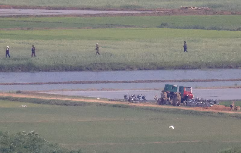 Người dân Triều Tiên làm việc trên cánh đồng lúa tại làng Kaepoong của Triều Tiên, nhìn từ Paju, Hàn Quốc, tháng 5/2023. Ảnh: REUTERS/Kim Hong-Ji Hình ảnh Triều Tiên thanh bình nhìn từ bên kia biên giới