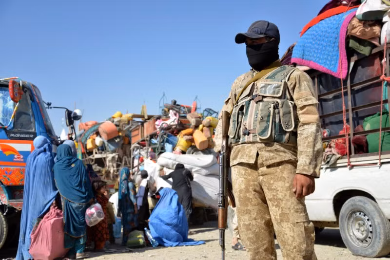 Cảnh sát Afghanistan đứng gác khi người dân từ Pakistan đến biên giới Afghanistan-Pakistan ở Spin Boldak, Afghanistan. (Ảnh: AFP). Hình ảnh người Afghanistan ùn ùn rời Pakistan