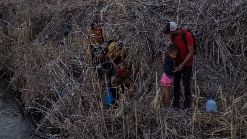 Các gia đình di cư di chuyển trên bờ sông Rio Grande, trong khi tìm kiếm giấy phép để vào Mỹ từ Mexico. Chùm ảnh tuyến đường di cư nguy hiểm nhất thế giới