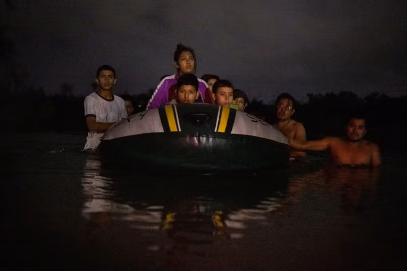 Nhân viên tuần tra biên giới soi đường cho người di cư xin tị nạn từ Trung Mỹ khi họ di chuyển qua bụi rậm từ Mexico và băng qua sông Rio Grande để đến Roma, Texas, Mỹ. Chùm ảnh tuyến đường di cư nguy hiểm nhất thế giới