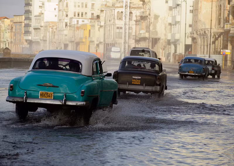 Ôtô chạy trên đại lộ ven biển El Malecon ngập nước ở Havana khi một đợt lạnh tràn qua Havana, tháng 11/2010. (Ảnh: REUTERS/Desmond Boylan) Chùm ảnh những chiếc xe cổ tuyệt đẹp trên đường phố Havana