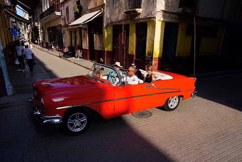 Khách du lịch lái chiếc ô tô cổ ở Havana, tháng 3/2024. (Ảnh: REUTERS/Alexandre Meneghini) Chùm ảnh những chiếc xe cổ tuyệt đẹp trên đường phố Havana
