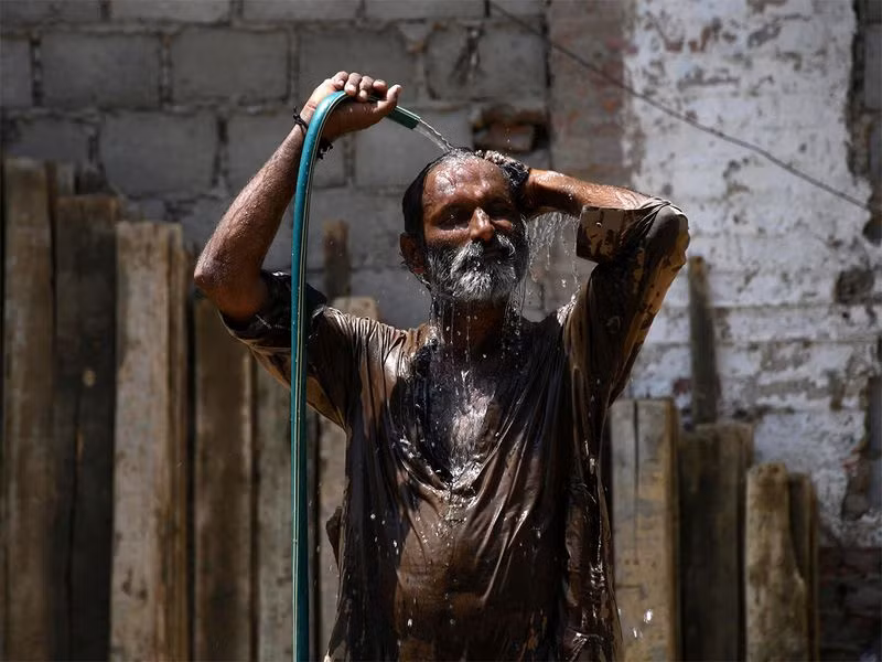 Một người tắm mát bằng vòi nước trong ngày hè nóng bức ở Hyderabad, Pakistan. Chùm ảnh người dân Pakistan trong cái nóng vượt 52 độ C