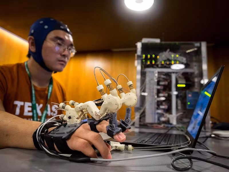 Một sinh viên của Texas Robotics trình diễn giao diện máy tính - não AI cho phép anh điều khiển bàn tay của mình bằng suy nghĩ. Robot chơi bóng đá tại Thượng đỉnh AI vì điều tốt đẹp