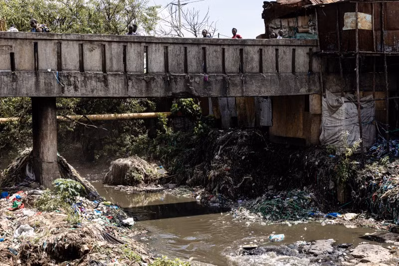 Những đồ bỏ đi phục vụ cho việc làm thảm hoặc bị vứt trên bờ sông Nairobi chảy cạnh chợ đồ cũ Gikomba. Khoảng 1/3 số quần áo là rác thải nhựa sẽ phân hủy thành các hạt gây ô nhiễm. Chùm ảnh chợ quần áo cũ khổng lồ ở Kenya