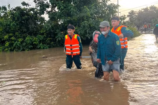 Lực lượng chức năng và người dân xã Hàm Thạnh đưa học sinh vượt qua vùng ngập, kịp dự lễ khai giảng.