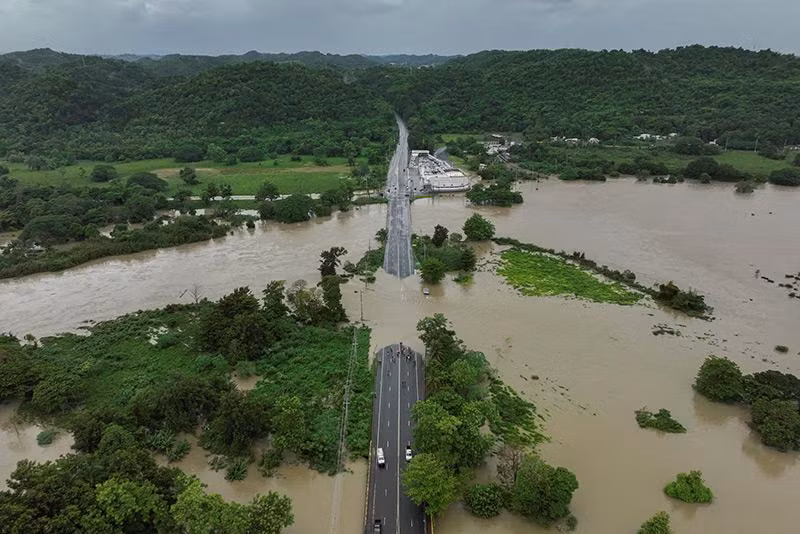 Góc nhìn từ trên cao cho thấy một cây cầu bị nhấn chìm bởi dòng sông La Plata ngập lụt sau cơn bão nhiệt đới Ernesto ở Toa Baja, Puerto Rico ngày 14/8. Ảnh: REUTERS khac-phuc-hau-qua-sau-bao-nhiet-doi-puerto-rico-01.jpg
