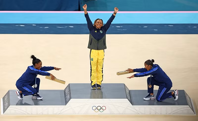 Trên bục vinh quang, cả người đoạt huy chương bạc Simone Biles và huy chương đồng Jordan Chiles của Đội tuyển Mỹ đều vui vẻ cúi chào người chiến thắng huy chương vàng, Rebeca Andrade của Đội tuyển Brazil tại Thế vận hội Paris 2024. Ảnh: Elsa / Getty top-25-anh-bao-chi-an-tuong-nhat-nam-2024-011.jpg