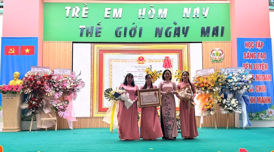 Bà Trương Thị Bích Hạnh, Phó Chủ tịch Thường trực Uỷ ban MTTQ Việt Nam TPHCM trao tặng Huân chương Lao động hạng Nhì cho Ban Giám hiệu Trường Mầm non Nhiêu Lộc. Ảnh: V.Phong