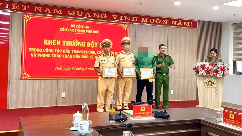 Công an TP Huế tổ chức khen thưởng đột xuất cho tài xế xe ôm và hai cán bộ CSGT. Ảnh: CA