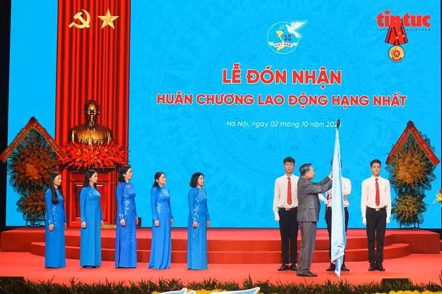 Tổng Bí thư Tô Lâm gắn Huân chương Lao động hạng Nhất lên lá cờ truyền thống của Hội LHPN Việt Nam.