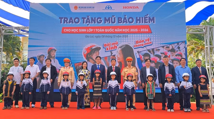Các đại biểu trao tặng mũ bảo hiểm cho các em học sinh lớp Một trường Tiểu học Lê Quý Đôn. Ảnh: Honda.
