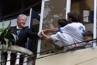 Ông Bill Clinton hôm 17/11/2000 bắt tay với những người dân Việt Nam từ ban công một tòa nhà đối diện Văn Miếu - Quốc Tử Giám, Hà Nội, trong chuyến thăm lịch sử. Ảnh: AP.